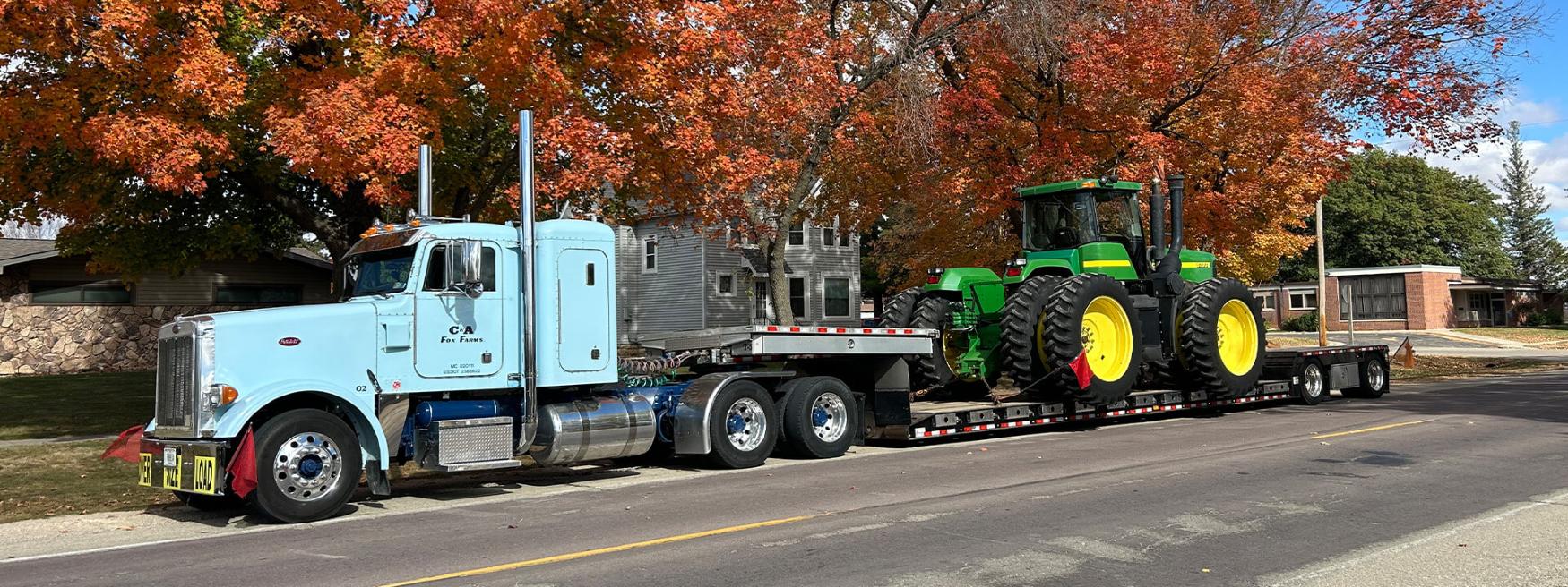 C&A Fox farms Semi carrying a John Deere Tractor in the fall